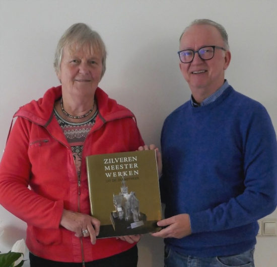 Jeanne Douwes en Arno Bruitsman tonen het eerste exemplaar van hun boek "Zilveren Meesterwerken uit de Zaanstreek"